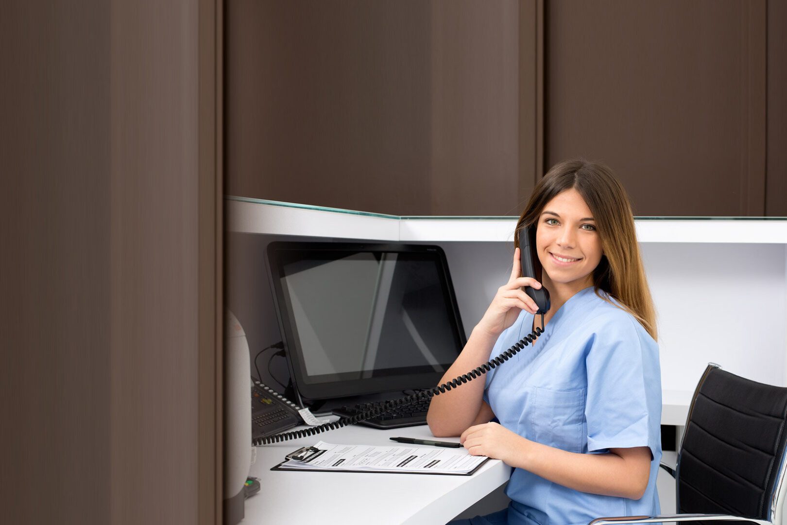 Nurse speaking on phone at workstation